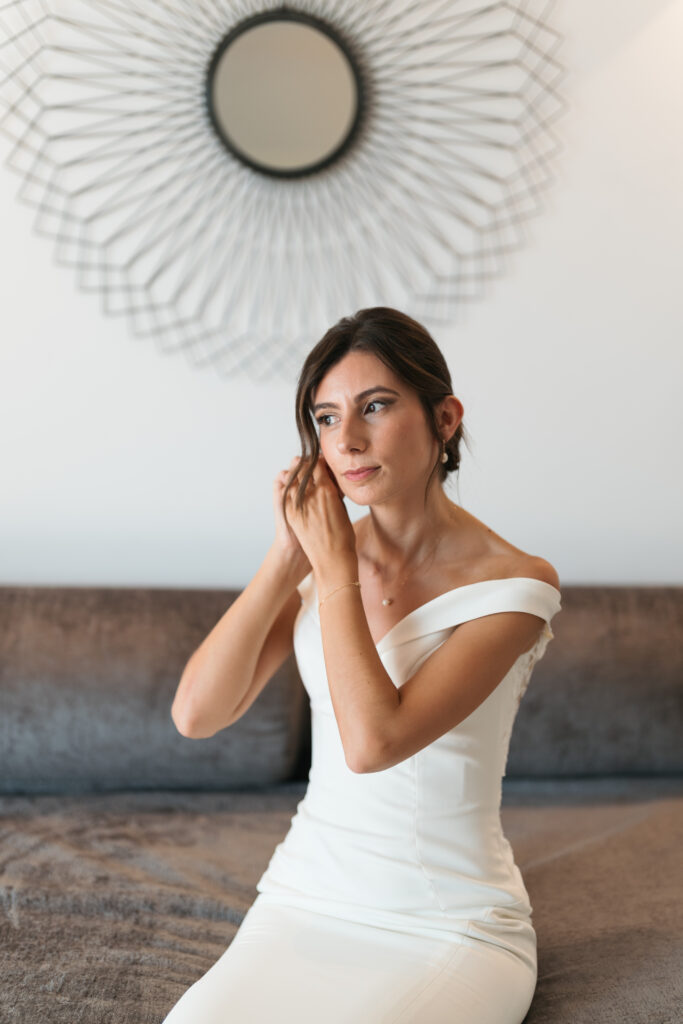Bride putting on pearl earrings. | Gabys Films