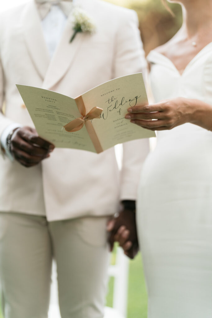 Couple holding cream wedding program. | Gabys Films