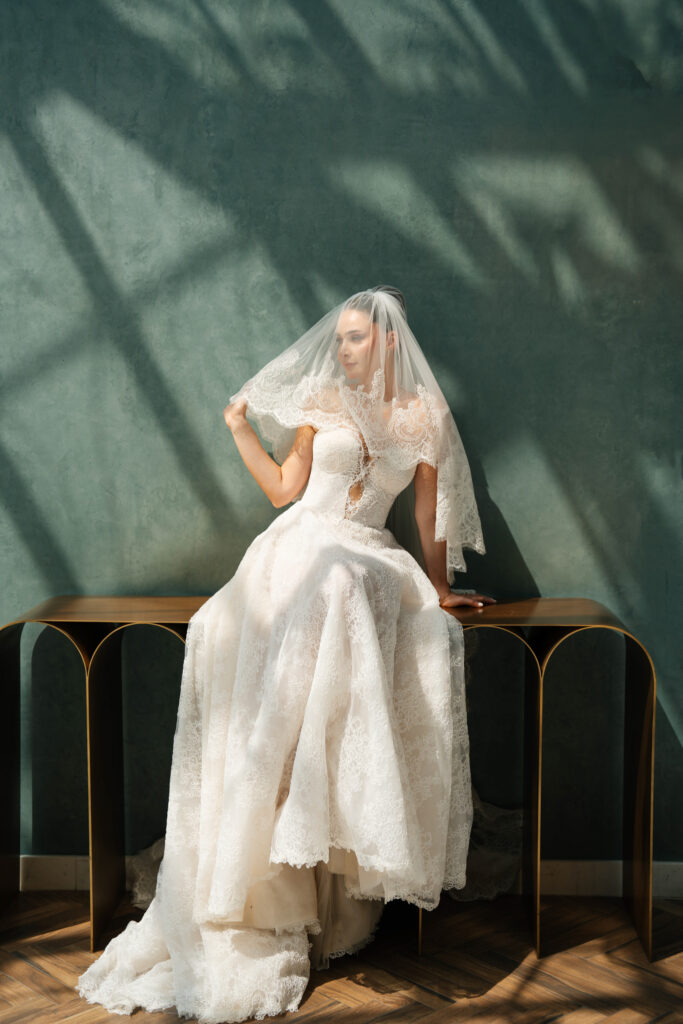 Bride sitting in lace gown. | Gabys Films